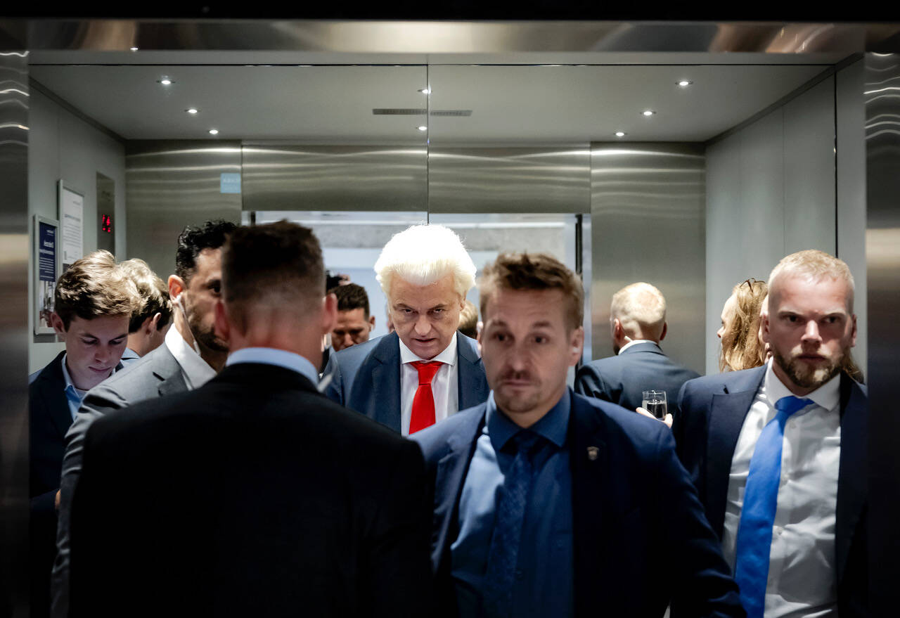 Geert Wilders omringd door beveiligers in de lift